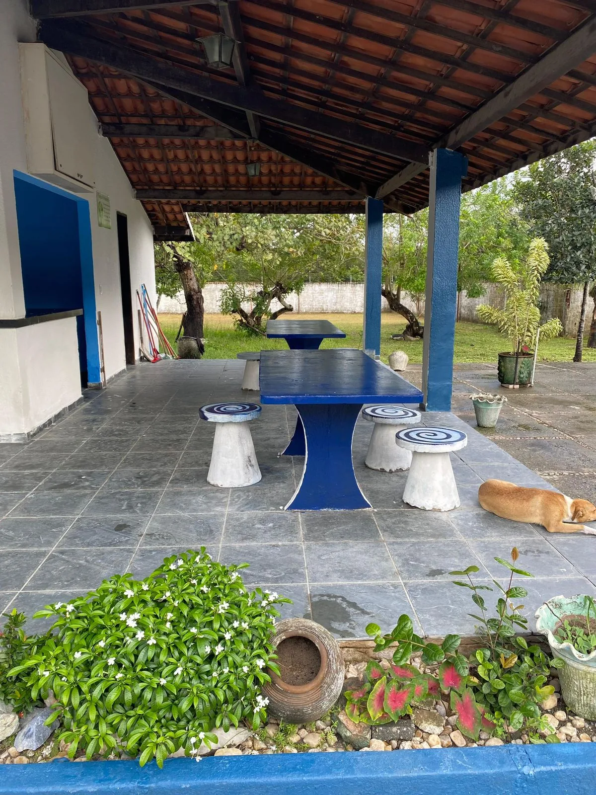 Espaço de convivência coberto com mesas para atividades em grupo